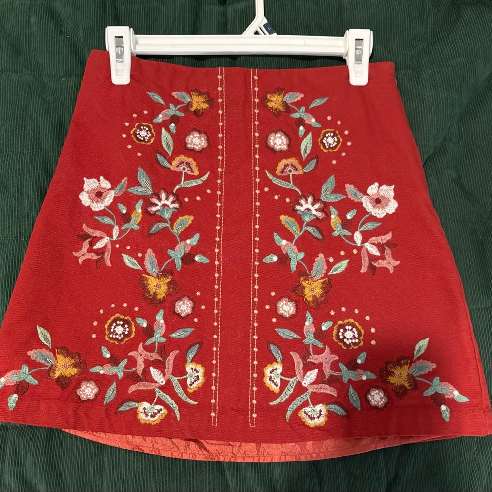 Red mini skirt with embroidered flowers.